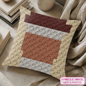 May include: A square throw pillow featuring a textured crochet pattern in a colour-blocked design. The pillow displays horizontal bands of dark brown, light grey, and terracotta orange, framed by a wide border of cream-coloured yarn stitches.