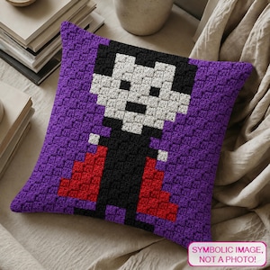 May include: A square crochet pillow cover featuring a pixelated vampire character design. The vampire has a white face, black hair, and a black suit with a red cape, set against a solid purple background. The texture is created with small squares.
