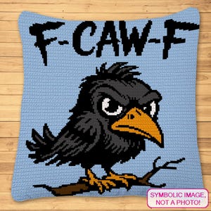 May include: A light blue crochet cushion with a cartoon crow design. The crow is black with an orange beak and feet, and the text "F-CAW-F" is above it. The cushion is square-shaped.