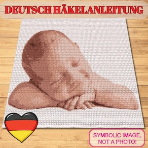 May include: A crocheted image of a baby lying down, with the text "DEUTSCH HÄKELANLEITUNG" at the top. The image is a light brown color and is on a white background. A heart with the German flag is in the lower left corner.