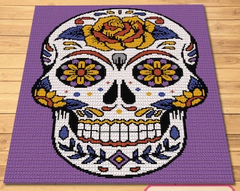 Puede incluir: Una calavera de azúcar colorida con fondo blanco, flores amarillas, naranjas, rojas, moradas y azules, y un fondo morado.