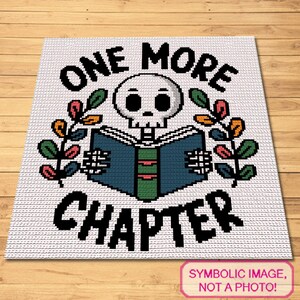 May include: A white crochet blanket featuring a pixelated design of a skull reading a blue book with a green spine. The text ONE MORE CHAPTER is written in black block letters above and below the skull, flanked by colorful leaf sprigs.