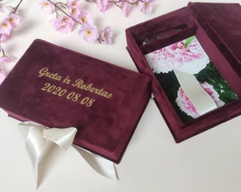 May include: Burgundy velvet box with a white satin ribbon and the inscription "Greta ir Robertas 2020 08 08". The box is open to reveal a white photo album with pink peonies.
