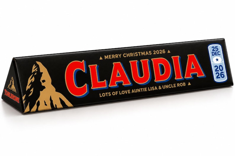 Pu&ograve; includere: Una scatola triangolare di cioccolato Toblerone con involucro nero. La parte anteriore presenta il nome CLAUDIA in grandi lettere rosse con contorni blu, il testo MERRY CHRISTMAS 2026, LOTS OF LOVE AUNTIE LISA & UNCLE ROB e un'etichetta 25 DEC 2026.