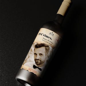 Puede incluir: Una botella de vino oscuro con una etiqueta crema que muestra la foto de un hombre y el texto "19 Crimes. Happy Birthday Love you loads." La botella tiene una base plateada y un cuello beige. Tambi&eacute;n aparece el nombre "Aaron".