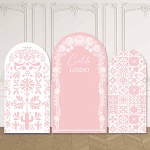 Könnte beinhalten: Drei bogenförmige Dekorationspaneele in Rosa und Weiß mit floralen und geometrischen Mustern. Das mittlere Panel zeigt den Schriftzug "Cielito Lindo". Geeignet als Kulisse für Veranstaltungen.