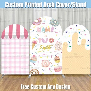 以下が含まれることがあります： パーティー用のアーチカバー3点セット。左側のカバーはピンクと白のギンガムチェック。中央のカバーはドーナツとアイスクリームをテーマにしたもので、「Name is Two Sweet」の文字が書かれています。右側のカバーは黄色と白のワッフルコーンで、スプリンクルがかけられています。