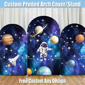 May include: A three-panel arch backdrop with a space theme. The backdrop features a blue and black galaxy background with stars, planets, and a rocket ship. The center panel features an astronaut in a white spacesuit. The text "Free Custom Any Design" is printed at the bottom of the backdrop.