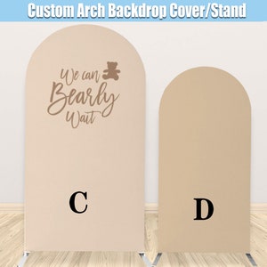 May include: Two beige arch backdrop covers, one with the text "We can Bearly Wait" and a teddy bear graphic, and the other blank. Both covers are labeled with letters C and D.