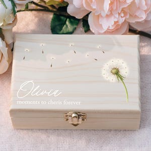 May include: A white wooden box with a dandelion design and the name "Olivia" and the text "moments to cherish forever".
