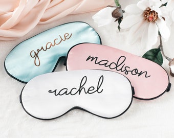May include: Three satin sleep masks with personalized names: Gracie, Madison, and Rachel. The masks are in shades of blue, pink, and white.