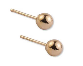 Puede incluir: Un par de pendientes de botón en forma de bola dorada con cabezas esféricas lisas. Cada poste está claramente marcado con el texto 14K y un símbolo de infinito, lo que indica la pureza del metal de estas piezas de joyería.