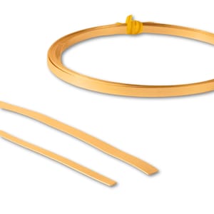 May include: A roll of gold-colored metal wire, approximately 1/4 inch wide, is coiled and tied with a yellow string. Two straight pieces of the same wire are also shown.