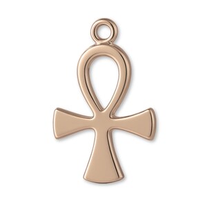 Pode incluir: Um pingente ankh de metal em tom de ouro rosa com uma superfície lisa e polida, apresentando um laço circular no topo para fixação. O berloque tem um formato de cruz clássico com um laço em forma de gota no topo.