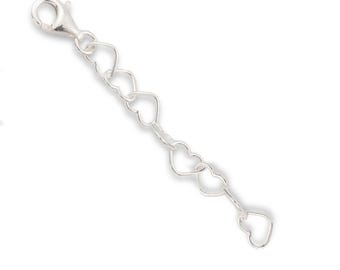 May include: A silver-toned metal jewelry extender chain featuring a series of interconnected heart-shaped links. The chain includes a lobster claw clasp at one end, allowing for adjustable length on necklaces or bracelets.