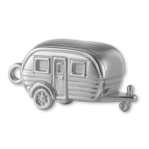 May include: A silver-coloured miniature travel trailer charm. The trailer features a rounded roof, windows, a door, and a hitch. The wheels and other details are clearly defined, giving the charm a realistic appearance. The charm has a loop for attaching to a bracelet or necklace.