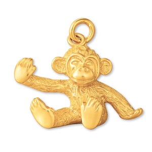 May include: A gold-toned monkey charm featuring a textured fur finish, a seated posture with one arm raised, and a circular jump ring attached to the top of the head for hanging. The monkey has detailed facial features and paws.