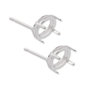 May include: A pair of silver earring settings with prongs for holding a stone. The settings are round and have a smooth finish.