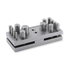 May include: A silver-coloured metal disc cutter tool featuring a rectangular base and top plate with multiple cylindrical punches of varying diameters. The top plate is engraved with the text ORE METALS and includes two hexagonal screw holes.