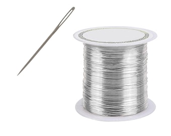 May include: A spool of silver-colored wire with a white plastic bobbin and a needle.