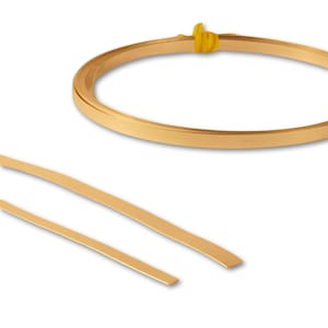 May include: A roll of gold-coloured metal trim, with two straight pieces of the same trim. The trim is flat and has a smooth, shiny finish.