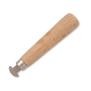 May include: A wooden handled tool with a metal, U-shaped tip. The tool is used for setting eyelets.