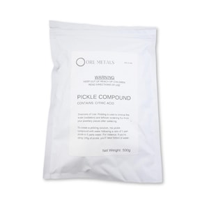 以下が含まれることがあります： ジュエリー作りのためのピクルスコンパウンドが入った白い袋。袋には「ピクルスコンパウンド」と表示され、クエン酸が含まれています。袋には、使用方法と子供の手の届かない場所に保管するよう警告する注意書きも記載されています。正味重量：500g