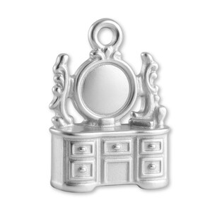 May include: A silver-colored charm in the shape of a vanity. The charm features a round mirror, decorative side elements, and a dresser with six drawers. The charm has a loop at the top for attaching to a bracelet or necklace.