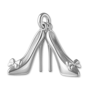 May include: A silver-toned metal charm shaped like a pair of high-heeled court shoes. Each shoe features a pointed toe, a slender stiletto heel, and a small decorative bow detail on the front. The charm includes a circular jump ring at the top.