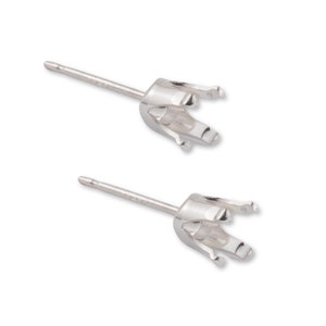May include: Two silver earring settings with prongs for holding a gemstone. The settings are attached to posts with backs.
