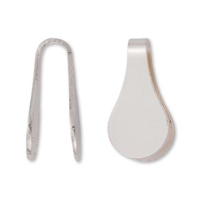 Puede incluir: Dos baúles de colgante de metal plateados, uno con forma de lágrima y el otro con forma de bucle simple.