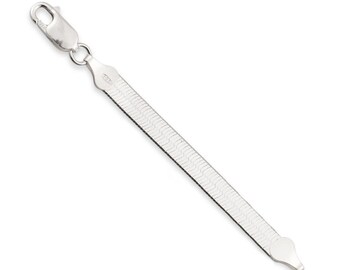 May include: A silver-toned herringbone chain bracelet featuring a flat, flexible link design with a polished finish. The bracelet includes a secure lobster claw clasp at one end and a smooth, rounded metal tab at the opposite end.