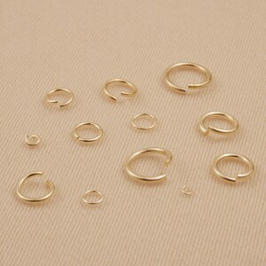 May include: Assortment of gold jump rings in various sizes, perfect for jewelry making or crafting projects.