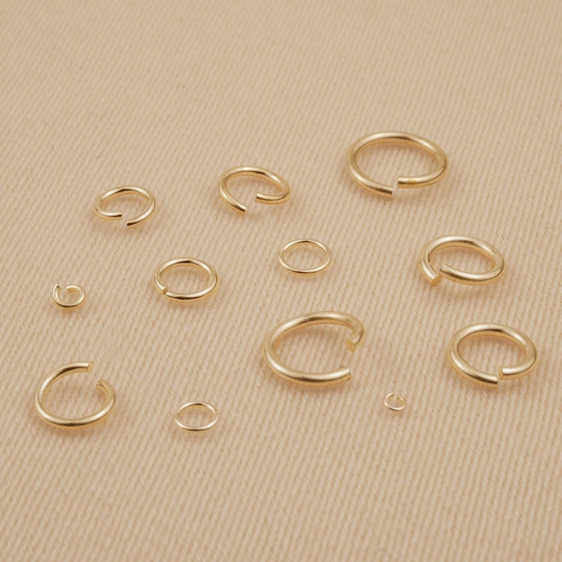 May include: Assortment of gold jump rings in various sizes, perfect for jewelry making or crafting projects.