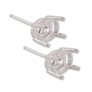 Puede incluir: Un par de engastes para pendientes de tono plateado con garras para sujetar una piedra. Los engastes son de forma ovalada y tienen un poste para sujetar a un pendiente.