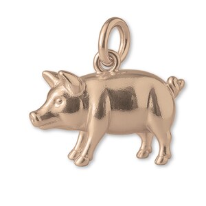 May include: A rose gold pig charm with a loop for a necklace or bracelet. The charm is a three-dimensional rendering of a pig, with detailed features including ears, snout, and a curled tail. The pig is standing on four legs.