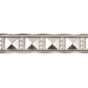 May include: Silver trim with a repeating pattern of small circles and diamond shapes.