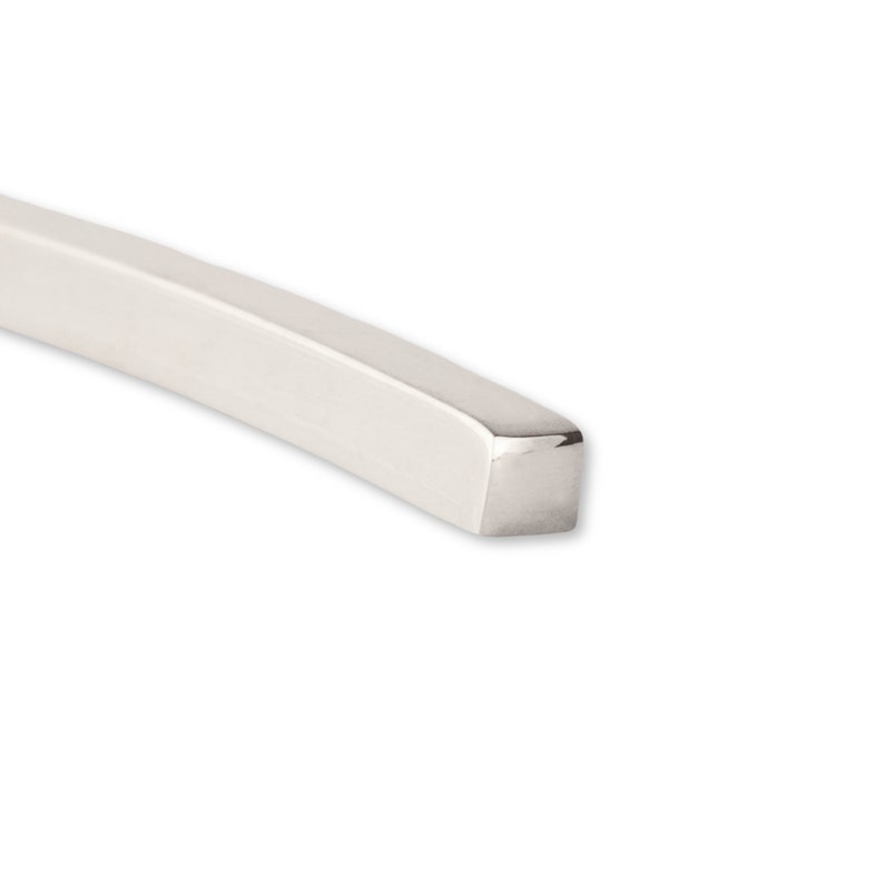 May include: A close-up of a silver, square-shaped, metal bar with rounded edges.