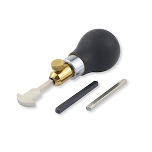 May include: A leathercraft edge creaser tool featuring a black bulbous handle, a brass adjustment knob, and a silver metal head. The tool is accompanied by two separate rectangular metal bars, one black and one silver, for interchangeable use.