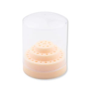 Peut inclure: Un récipient de rangement cylindrique en plastique transparent avec un couvercle amovible, contenant un support circulaire à étages de couleur pêche clair, doté de multiples petits trous régulièrement espacés en cercles concentriques.