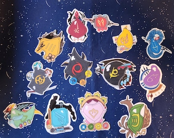May include: A collection of 12 colorful stickers featuring various designs, including a purple creature, a green creature, a yellow creature, a red shield, a black shield, a blue shield, a yellow and black shield, a green and yellow shield, a pink shield, a black and yellow creature, a blue creature, and a green creature.