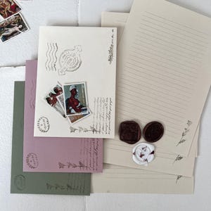 May include: A set of three envelopes with lined paper, each with a different color: green, pink, and beige. The envelopes have decorative stamps and wax seals. The envelopes are perfect for sending letters or notes.