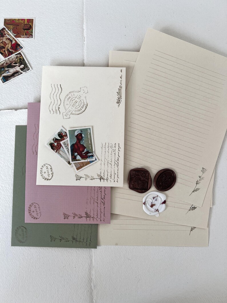 May include: A set of three envelopes with lined paper, each with a different color: green, pink, and beige. The envelopes have decorative stamps and wax seals. The envelopes are perfect for sending letters or notes.