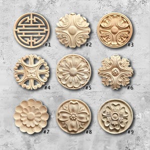 May include: Nine intricately carved wooden decorative medallions in various floral and geometric designs. Each medallion is circular, with detailed relief patterns. The natural wood color highlights the carved details. Numbers #1 through #9 are visible.