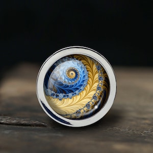 Peut inclure: Une bague en argent avec un motif en spirale bleu et or à l'intérieur d'un dôme en verre transparent.