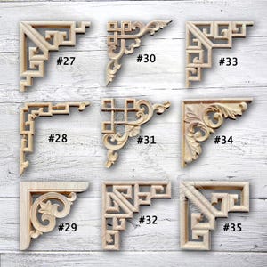 Peut inclure: Ensemble de neuf équerres d'angle en bois non finies, chacune avec un design sculpté unique. Les équerres sont numérotées de #27 à #35, présentant divers motifs géométriques et floraux. La couleur naturelle du bois met en valeur les détails.