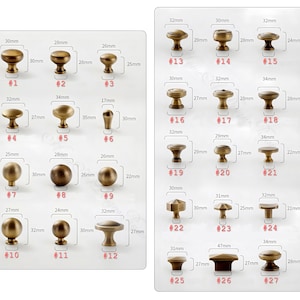 May include: A selection of antique brass cabinet knobs in diverse styles, each numbered and with measurements in millimeters. The knobs vary in shape, from spherical to mushroom, with sizes ranging from 17mm to 34mm.