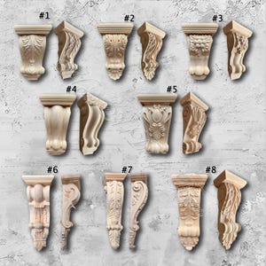 May include: A collection of eight unfinished wooden corbels, each with a unique carved design. The corbels feature various floral and scroll patterns, ideal for decorative architectural accents. The corbels are numbered from one to eight.