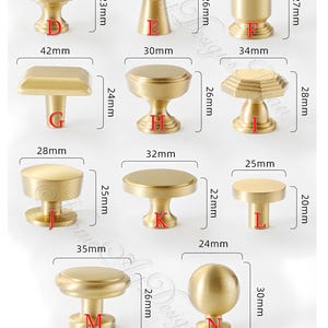 Puede incluir: Una colecci&oacute;n de pomos y tiradores dorados para armarios en varios dise&ntilde;os. Los pomos var&iacute;an en tama&ntilde;o, el m&aacute;s grande mide 45 mm de ancho. La imagen muestra diferentes formas, incluyendo opciones redondas, cuadradas y hexagonales.