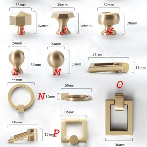 Puede incluir: Una colecci&oacute;n de herrajes de lat&oacute;n para armarios, que incluye pomos y tiradores. La imagen muestra varios dise&ntilde;os, como pomos cuadrados, redondos y en forma de T, con medidas en mil&iacute;metros. Los herrajes tienen un acabado met&aacute;lico c&aacute;lido.